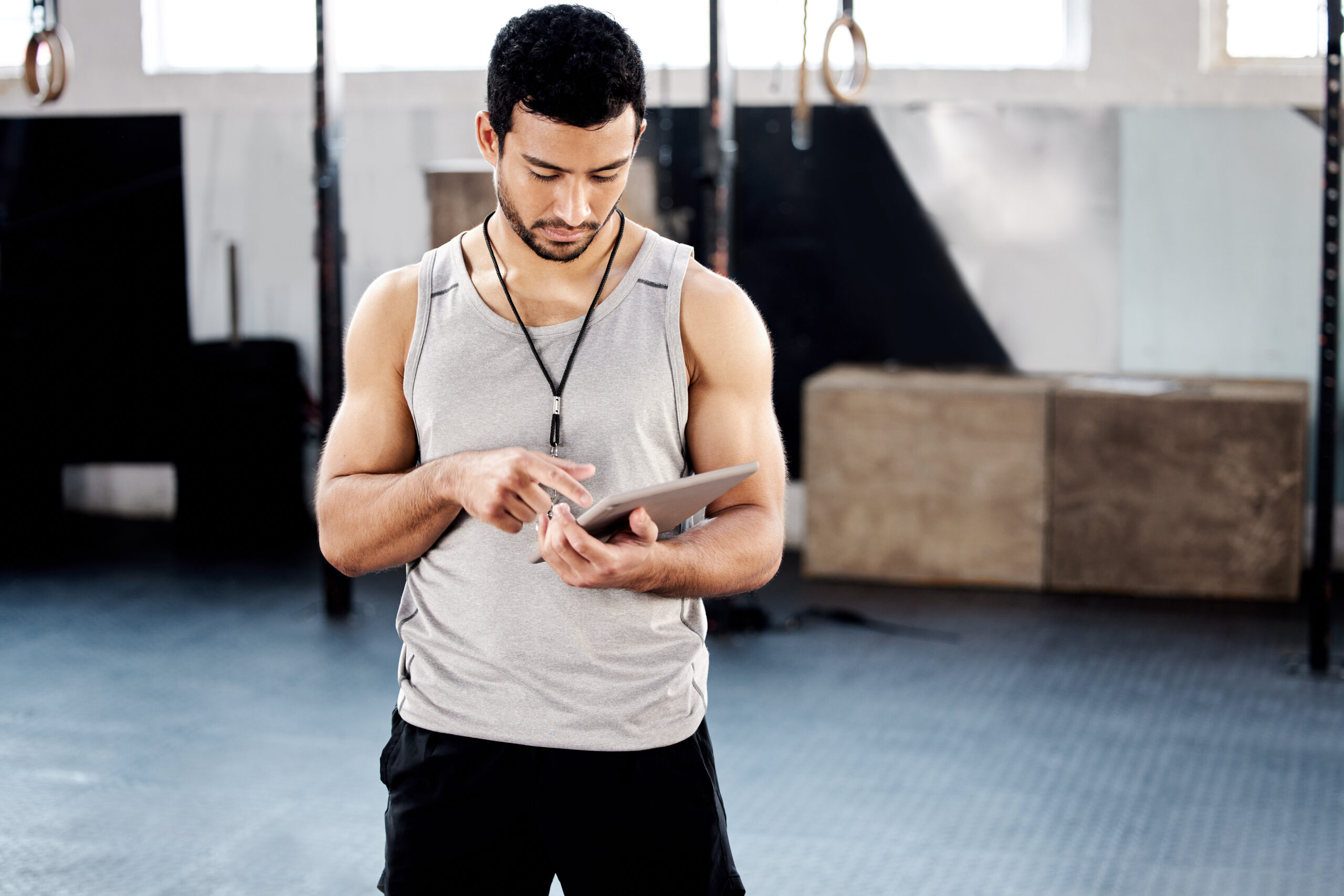 shot of a handsome young man using a digital tablet at the gym